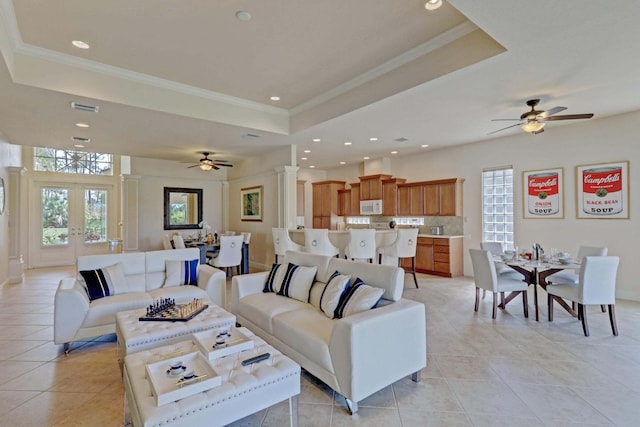 living room featuring light tile patterned floors, a tray ceiling, and a wealth of natural light