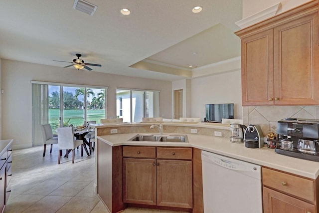 kitchen featuring a raised ceiling, ceiling fan, sink, light tile patterned floors, and dishwasher