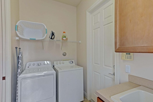 laundry room with washer and clothes dryer, cabinets, and sink