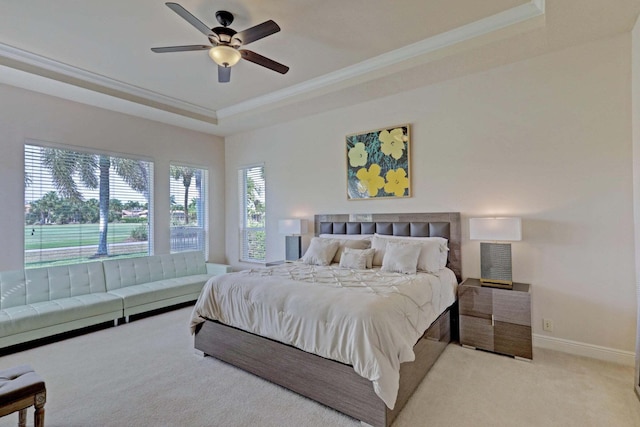 bedroom featuring ceiling fan, a raised ceiling, light colored carpet, and crown molding