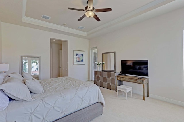 carpeted bedroom featuring a tray ceiling and ceiling fan