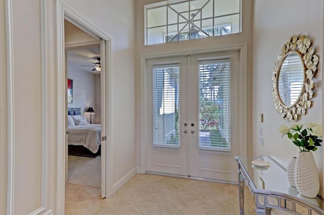 entryway featuring ceiling fan, french doors, and light tile patterned flooring