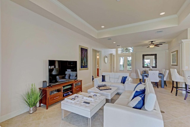 tiled living room with a tray ceiling, ceiling fan, french doors, and ornamental molding