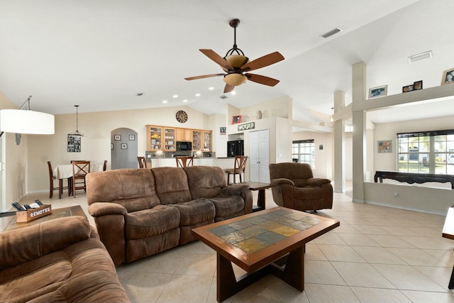 living room with lofted ceiling, ceiling fan, and light tile patterned flooring