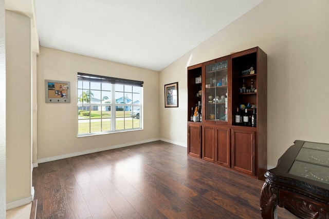 dining room with lofted ceiling and dark wood-type flooring