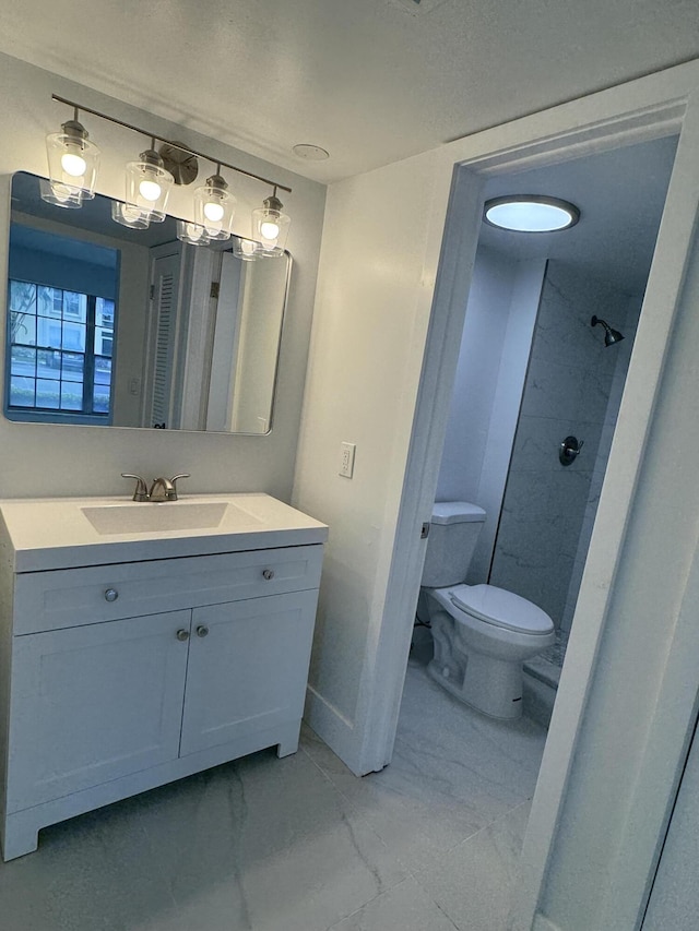 bathroom with a shower, vanity, and toilet