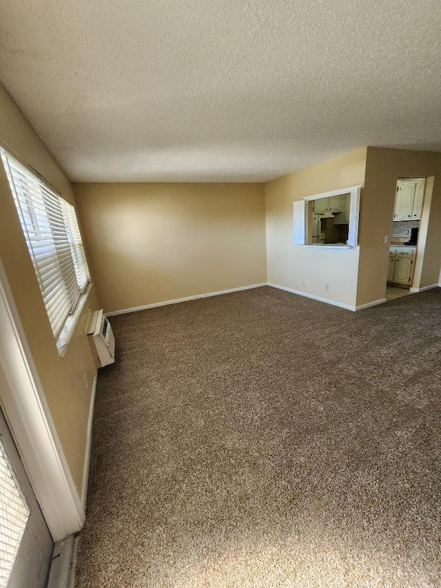 unfurnished living room featuring carpet flooring, a textured ceiling, and a wall mounted air conditioner