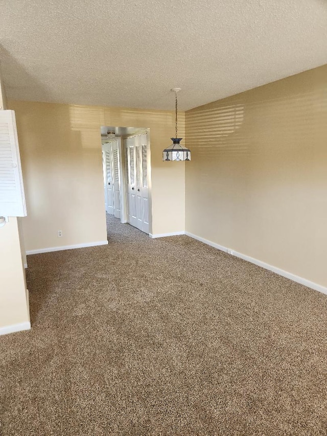 unfurnished dining area featuring carpet flooring and a textured ceiling