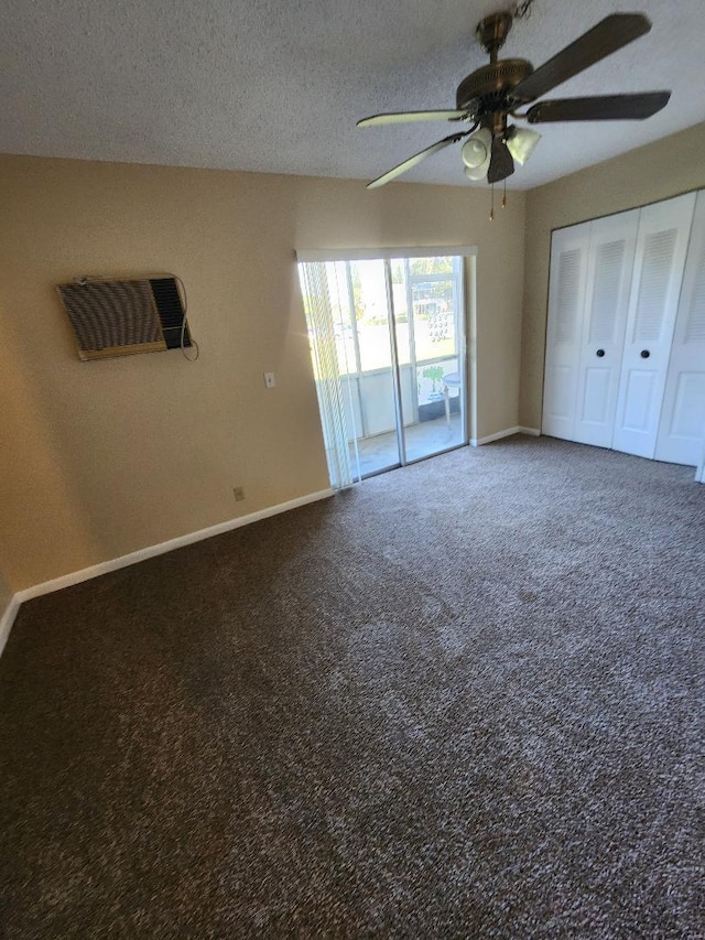 unfurnished bedroom featuring a wall mounted air conditioner, a textured ceiling, access to outside, ceiling fan, and dark colored carpet