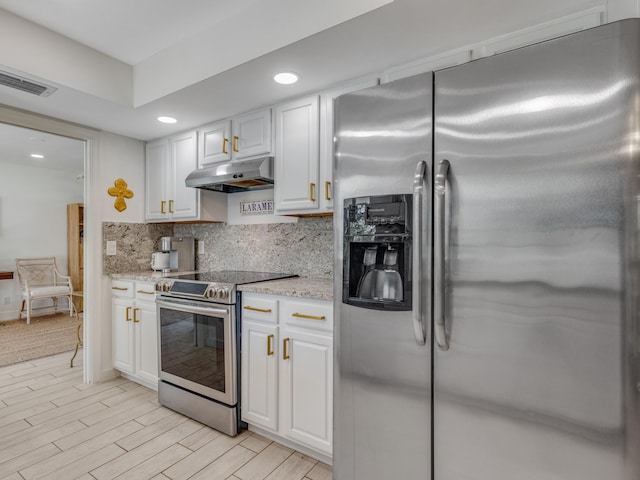 kitchen with light stone countertops, appliances with stainless steel finishes, white cabinets, and decorative backsplash