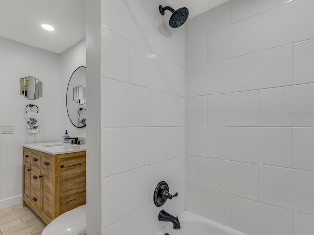 full bathroom featuring tiled shower / bath combo, vanity, hardwood / wood-style floors, and toilet