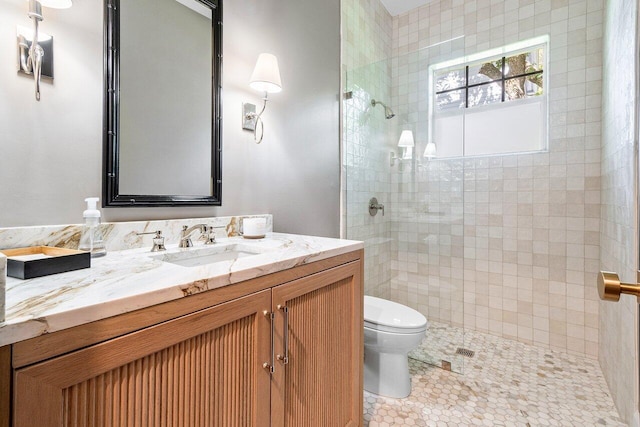 bathroom with vanity, a tile shower, tile patterned floors, and toilet