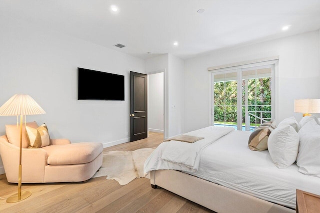 bedroom with access to exterior and light hardwood / wood-style flooring