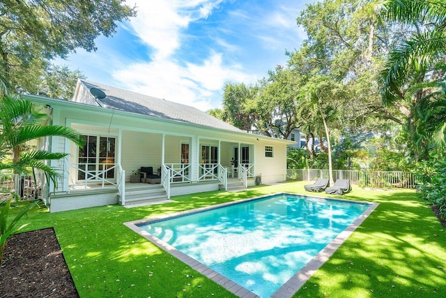 back of house with a fenced in pool and a yard