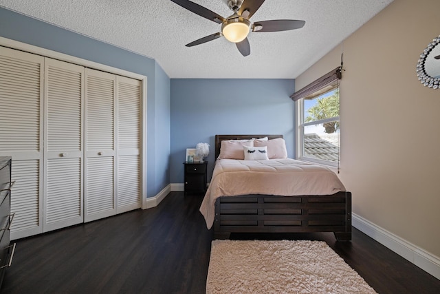 bedroom featuring dark hardwood / wood-style flooring, a textured ceiling, ceiling fan, and a closet