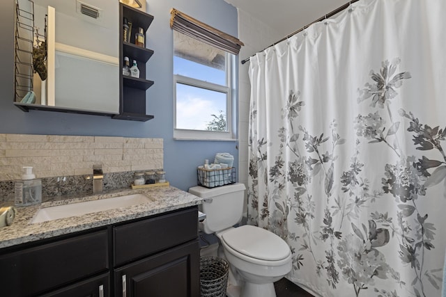 bathroom with vanity, backsplash, toilet, and walk in shower