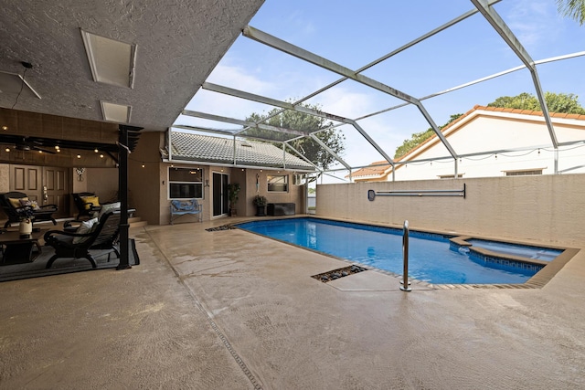 view of pool featuring a patio area, an in ground hot tub, and glass enclosure