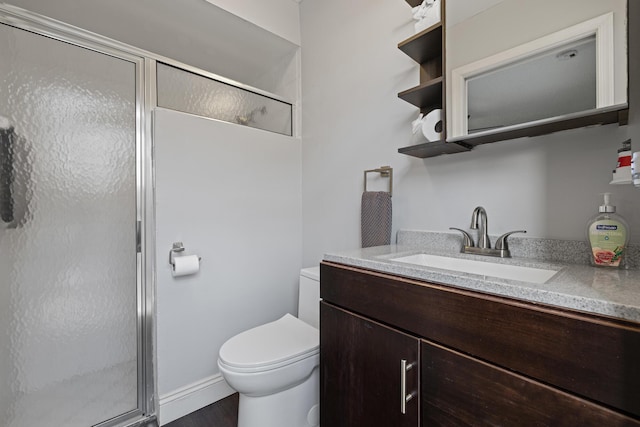 bathroom with vanity, toilet, and a shower with door