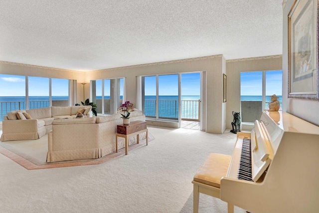 living room featuring a water view, light colored carpet, and a textured ceiling