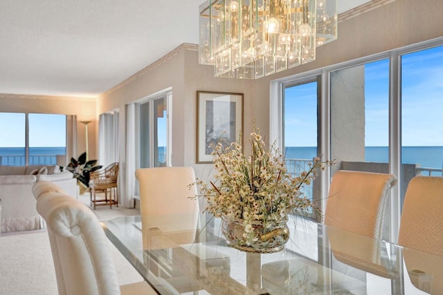 dining area with a water view, a healthy amount of sunlight, and an inviting chandelier