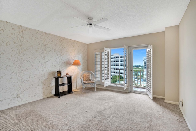 unfurnished room featuring ceiling fan, carpet, and a textured ceiling