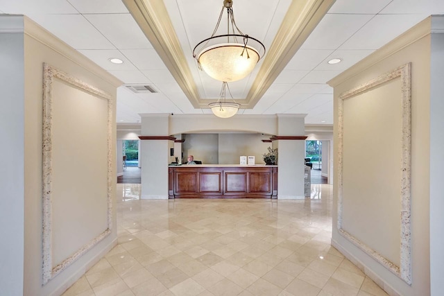 hallway featuring crown molding and a raised ceiling