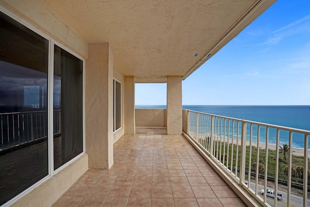 balcony with a beach view and a water view