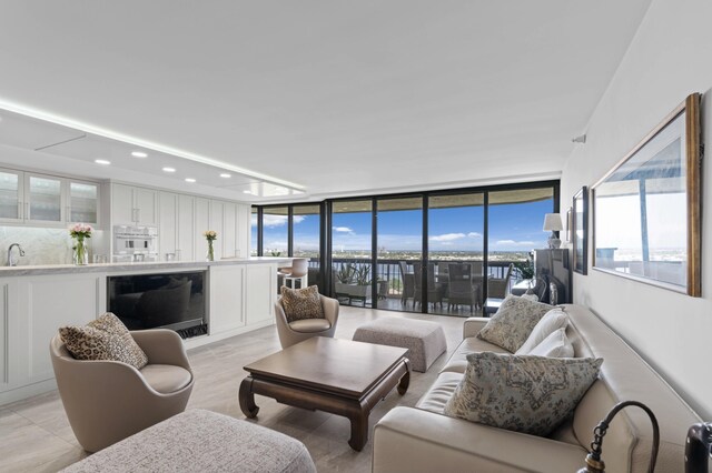 kitchen with appliances with stainless steel finishes, white cabinetry, expansive windows, and sink