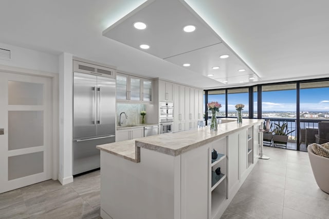 1900 Consulate Pl Unit 1902, West Palm Beach, FL 33401 - kitchen with a kitchen island, appliances with stainless steel finishes, sink, and white cabinets