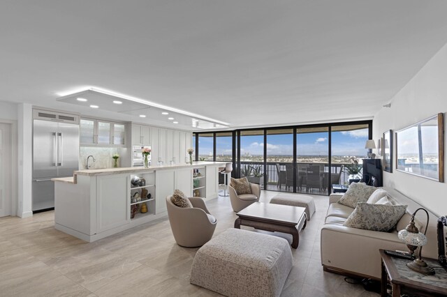 bedroom featuring access to outside, a water view, tile patterned flooring, ceiling fan, and a wall of windows