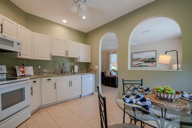 kitchen featuring white cabinetry, sink, light tile patterned floors, and white appliances