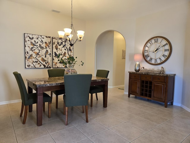 tiled dining area featuring a chandelier