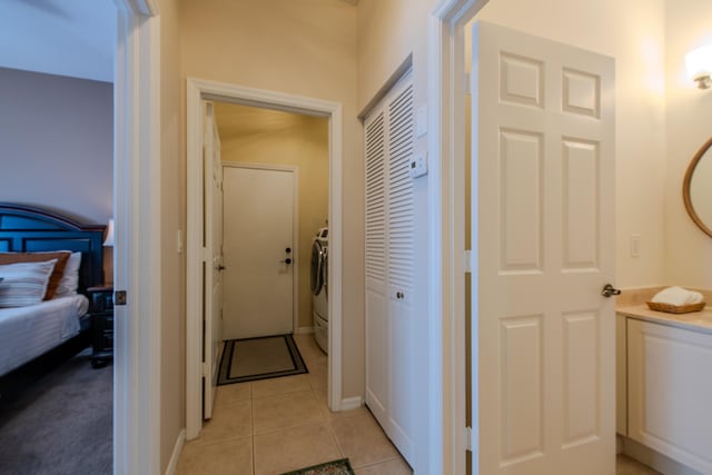 corridor with light tile patterned floors and washer / clothes dryer