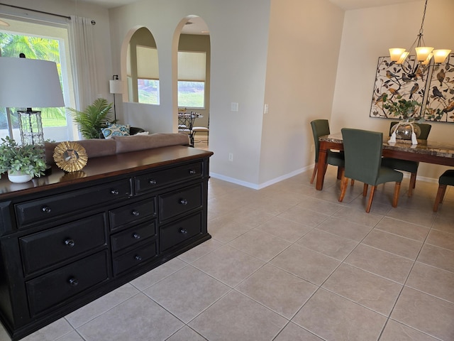 dining area with light tile patterned floors and an inviting chandelier