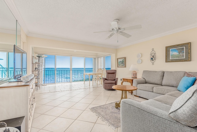 living room featuring a textured ceiling, light tile patterned flooring, a water view, and crown molding