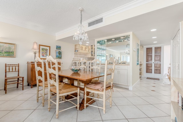 dining room featuring a textured ceiling, a notable chandelier, and light tile patterned floors