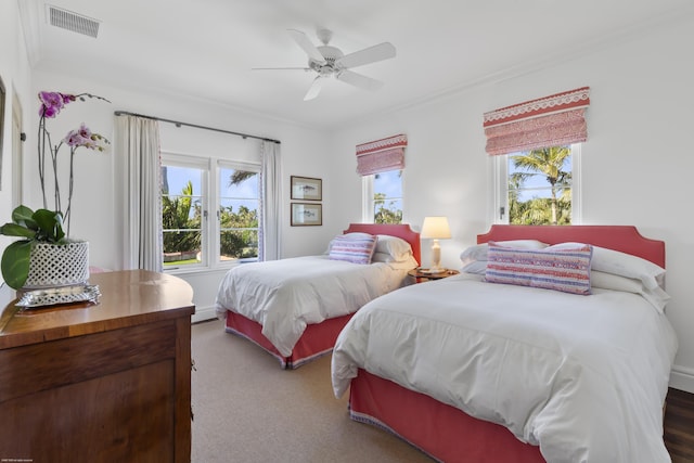 carpeted bedroom featuring ornamental molding and ceiling fan