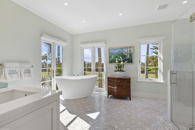 bathroom with ornamental molding, plenty of natural light, independent shower and bath, and vanity