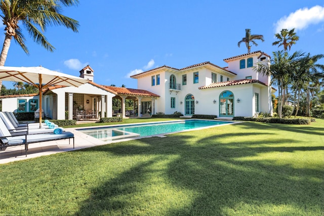 rear view of house featuring a lawn, a patio, and french doors