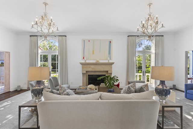 living room featuring ornamental molding, a healthy amount of sunlight, and a chandelier