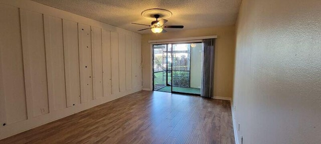 unfurnished room featuring a textured ceiling, dark hardwood / wood-style floors, and ceiling fan