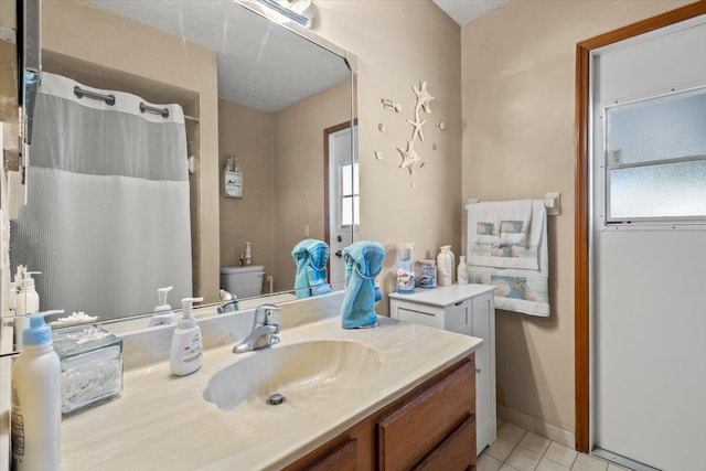 bathroom featuring tile patterned floors, vanity, toilet, and a textured ceiling