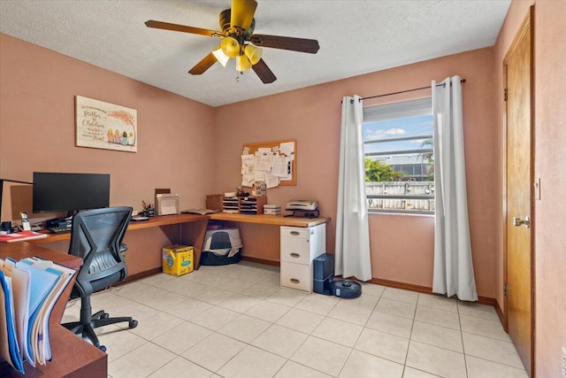 office space featuring ceiling fan, light tile patterned flooring, and a textured ceiling