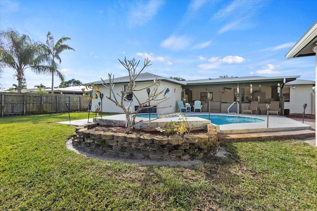 back of property featuring a fenced in pool, ceiling fan, a lawn, and a patio