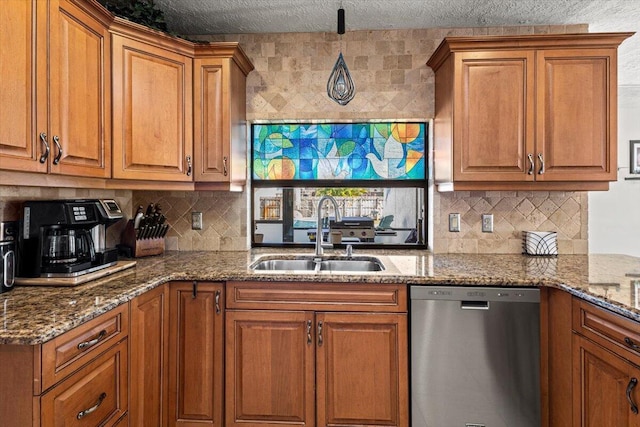 kitchen featuring tasteful backsplash, stainless steel dishwasher, dark stone countertops, and sink