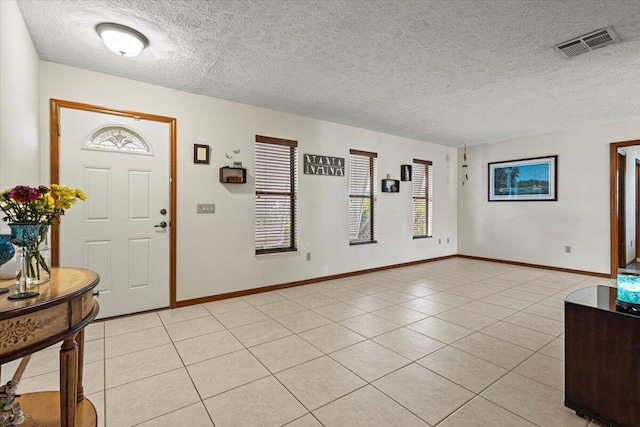 tiled foyer entrance featuring a textured ceiling