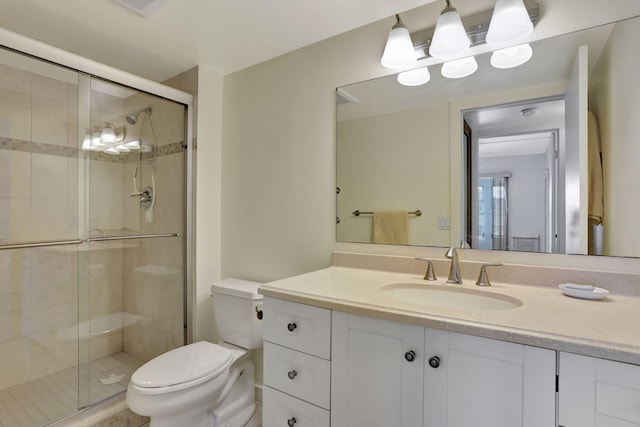 bathroom featuring walk in shower, vanity, and toilet