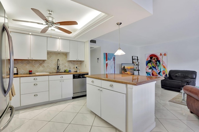 kitchen featuring stainless steel appliances, sink, white cabinets, pendant lighting, and a tray ceiling