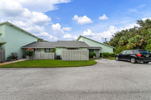 ranch-style house with central AC unit and a front yard