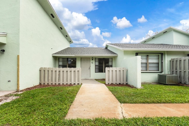 exterior space featuring central AC unit and a lawn